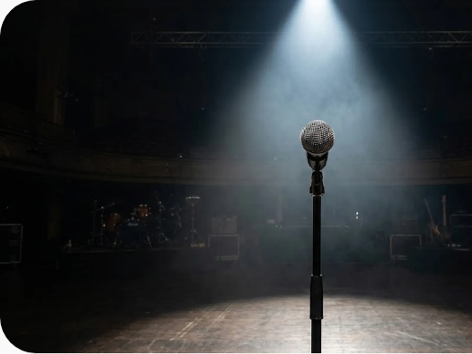 vocal microphone on a stage lit by a dramatic spotlight